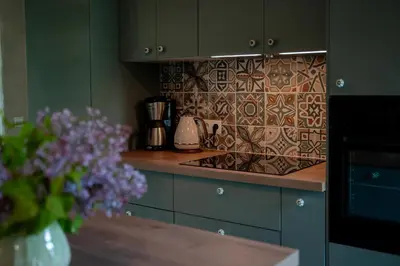 a kitchen with a counter with a tile back splash at Pramogų namelis