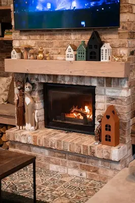 a fireplace with a tv on top of it at Pramogų namelis