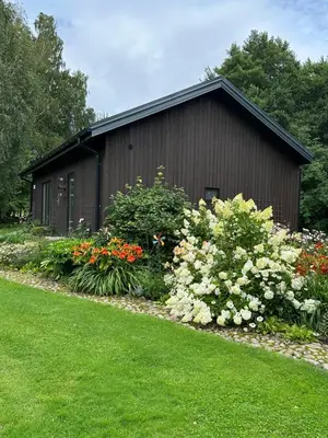a small building with flowers in front of it at Pramogų namelis