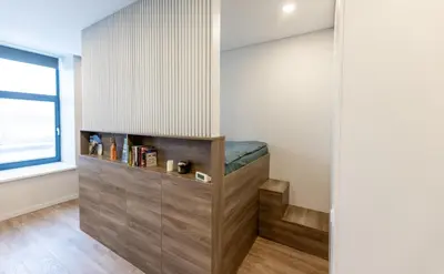 a home office with a bench in the corner of a room at Vincent Urban Nest - Near Clinic, Arena and Stadium in Kaunas