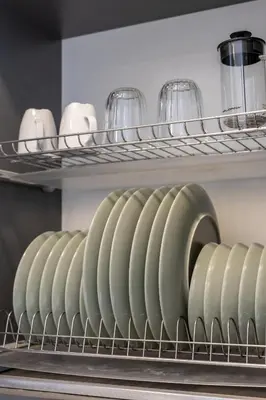 a row of green vases and glasses on a shelf at Vincent Urban Nest - Near Clinic, Arena and Stadium in Kaunas