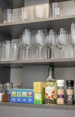 a shelf with wine glasses and other items on it at Vincent Urban Nest - Near Clinic, Arena and Stadium in Kaunas