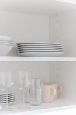 a shelf with wine glasses and plates on it at Nemunas A respite Studio 8 in Druskininkai