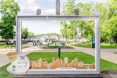 a sign in a frame in a park at Nemunas A respite Studio 8 in Druskininkai