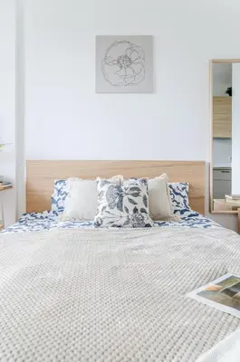 a bedroom with a large bed with blue and white pillows at Nemunas A respite Studio 8 in Druskininkai