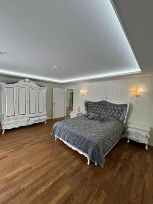 a large bedroom with a bed and white cabinets at Classic Style Apartment in Kelmė