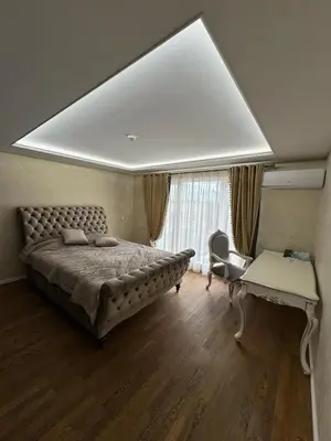 a bedroom with a large bed and a desk at Classic Style Apartment in Kelmė