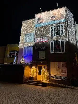 a building with christmas lights on the side of it at Classic Style Apartment in Kelmė