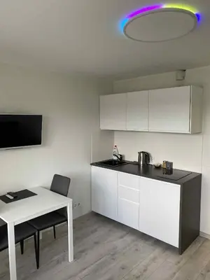 a kitchen with a table and a purple light on the ceiling at Vilnius Apartment with Balcony in Vilnius