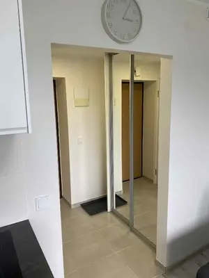 a clock on a wall in a hallway with a mirror at Vilnius Apartment with Balcony in Vilnius