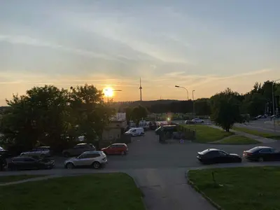 a parking lot with cars parked in front of the sunset at Vilnius Apartment with Balcony in Vilnius