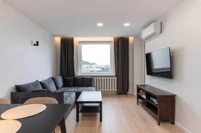 a living room with a couch and a tv at Panorama City View Apartment in Vilnius