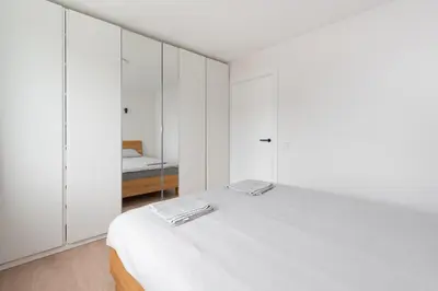 a white bedroom with white cabinets and a bed at Panorama City View Apartment in Vilnius