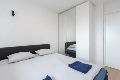 a bedroom with a white bed and a mirror at Panorama City View Apartment in Vilnius