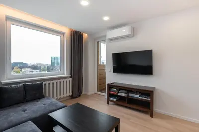 a living room with a couch and a flat screen tv at Panorama City View Apartment in Vilnius