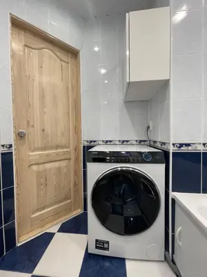 a washing machine in a kitchen with a door at Dani apartment in Panevėžys