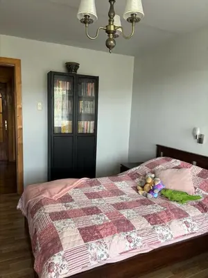 a bedroom with a bed with a quilt on it at Ramybės kotedžas in Kaunas