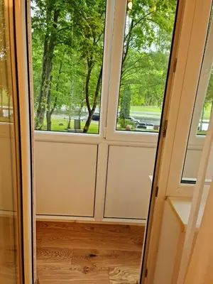 a door leading into a room with two windows at Saulės laikrodžio apartamentai in Šiauliai