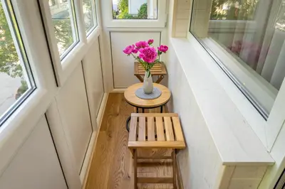 a tiny house with a vase of flowers on a table at Saulės laikrodžio apartamentai in Šiauliai