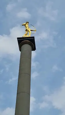 a statue of a man with a racket on a pole at Saulės laikrodžio apartamentai in Šiauliai