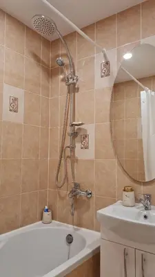 a bathroom with a shower and a tub and a sink at Saulės laikrodžio apartamentai in Šiauliai
