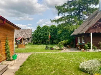 a yard with a house and a flag at Prienų vienkiemis in Kelmė