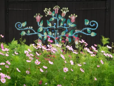 a field of pink flowers in front of a fence at Prienų vienkiemis in Kelmė