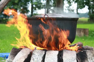a pot sitting on top of a camp fire at Prienų vienkiemis in Kelmė
