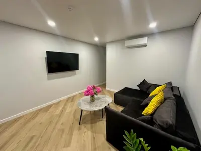 a living room with a black couch and a tv at Butas nuomai truputį daugiau nei kilometras pėsčiomis iki Senamiesčio in Kaunas