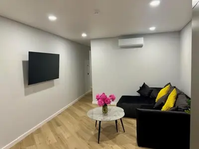 a living room with a couch and a table with flowers at Butas nuomai truputį daugiau nei kilometras pėsčiomis iki Senamiesčio in Kaunas