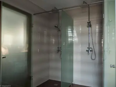 a shower with a glass door in a bathroom at Villa Emilė in Kontverki