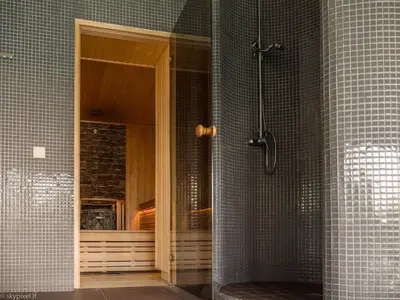 a shower with a glass door in a bathroom at Villa Emilė in Kontverki