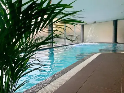 a swimming pool with a plant in a building at Villa Emilė in Kontverki