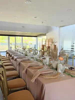 a long row of tables with chairs and tablecloths at Villa Emilė in Kontverki