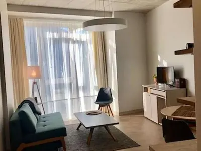 a living room with a couch and a table in front of a window at HaPPy Inn PLENTIFUL OLD Town Studio, Self check-in, AC, Parking in the underground Garage in Vilnius