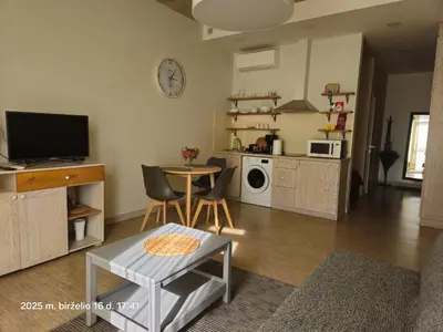 a living room with a table and a kitchen at HaPPy Inn PLENTIFUL OLD Town Studio, Self check-in, AC, Parking in the underground Garage in Vilnius