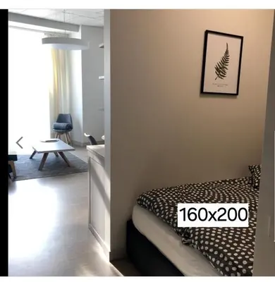 a bedroom with a bed in a room with a sign at HaPPy Inn PLENTIFUL OLD Town Studio, Self check-in, AC, Parking in the underground Garage in Vilnius