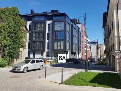 a car parked in a parking lot in front of a building at HaPPy Inn PLENTIFUL OLD Town Studio, Self check-in, AC, Parking in the underground Garage in Vilnius