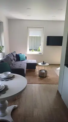 a living room with a couch and a table at Lake apartments in Rokiškis