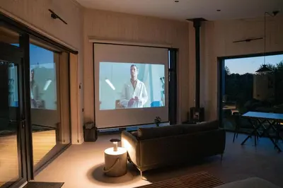 a living room with a tv with a man on it at Juoda Truoba