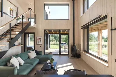 a living room with a green couch and a staircase at Juoda Truoba