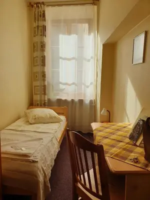 a bedroom with two beds and a desk and a window at Litinterp in Vilnius