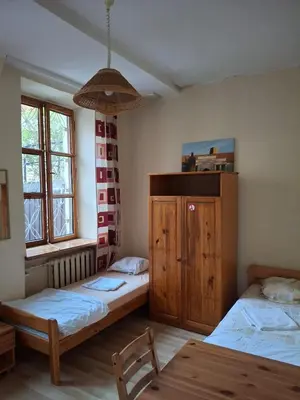 a bedroom with two beds and a wooden cabinet at Litinterp in Vilnius