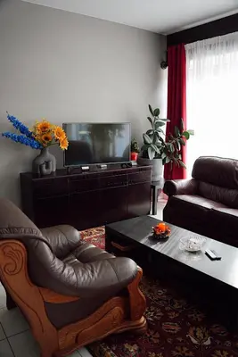 a living room with a couch and a television at GP Hostel in Šiauliai