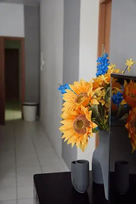 a vase filled with yellow and blue flowers on a table at GP Hostel in Šiauliai
