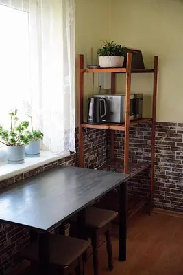 a wooden table in a room with a microwave at GP Hostel in Šiauliai