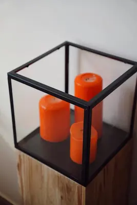 a glass box with two orange candles in it at GP Hostel in Šiauliai