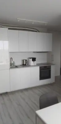a white kitchen with white cabinets and a table at Buto nuoma Druskininkuose in Druskininkai