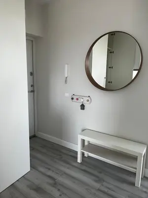 a white room with a mirror and a bench at Buto nuoma Druskininkuose in Druskininkai