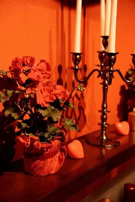a vase of flowers on a table with two candles at GP Hostel in Šiauliai